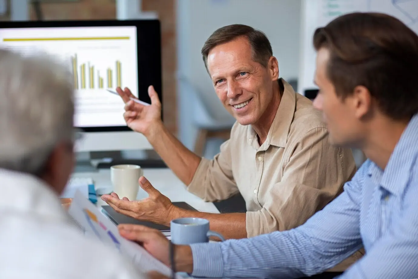 Menschen, die während eines Meetings ein digitales Gerät benutzen