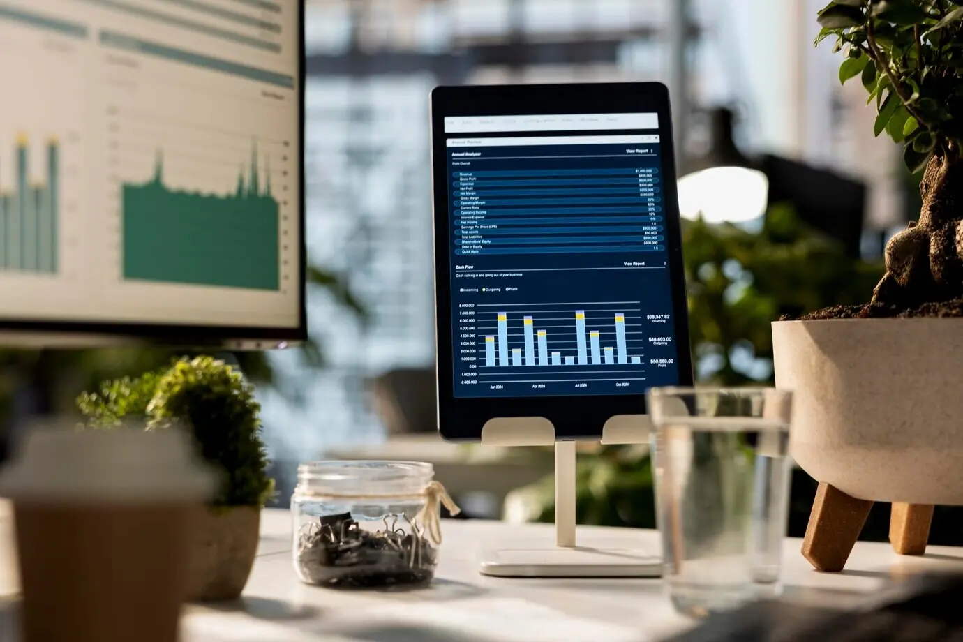 Leerer Geschäftsarbeitsplatz mit einem Gerät, das Datenanalysen und Infografiken anzeigt.